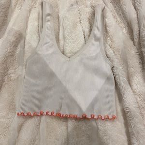 White tank top with orange ruffle on the bottom